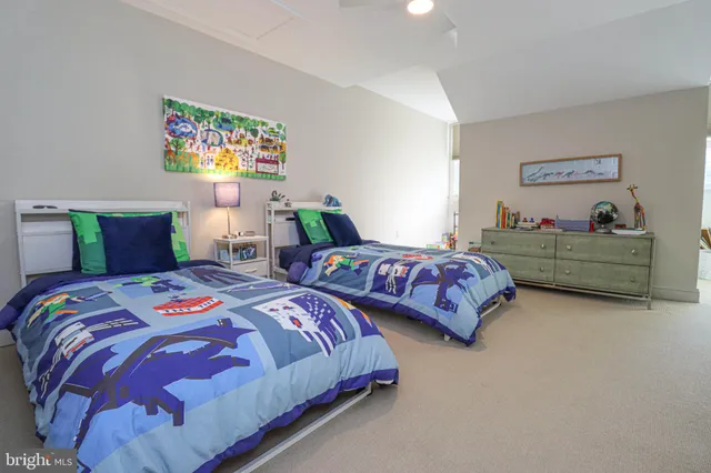 a bedroom with two beds and painting on the wall