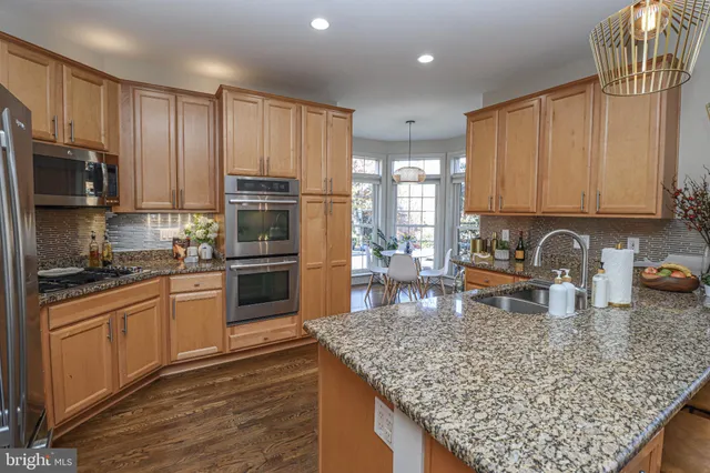 a kitchen with stainless steel appliances granite countertop a stove refrigerator sink and cabinets
