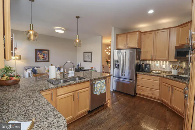 a kitchen with refrigerator a sink and chairs