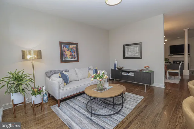 a living room with furniture and a dining table with wooden floor