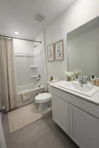 a bathroom with a double vanity sink toilet and shower