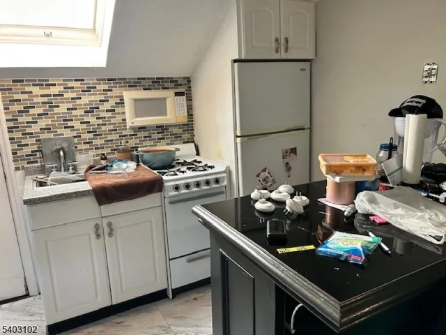a kitchen with stainless steel appliances a stove refrigerator and sink