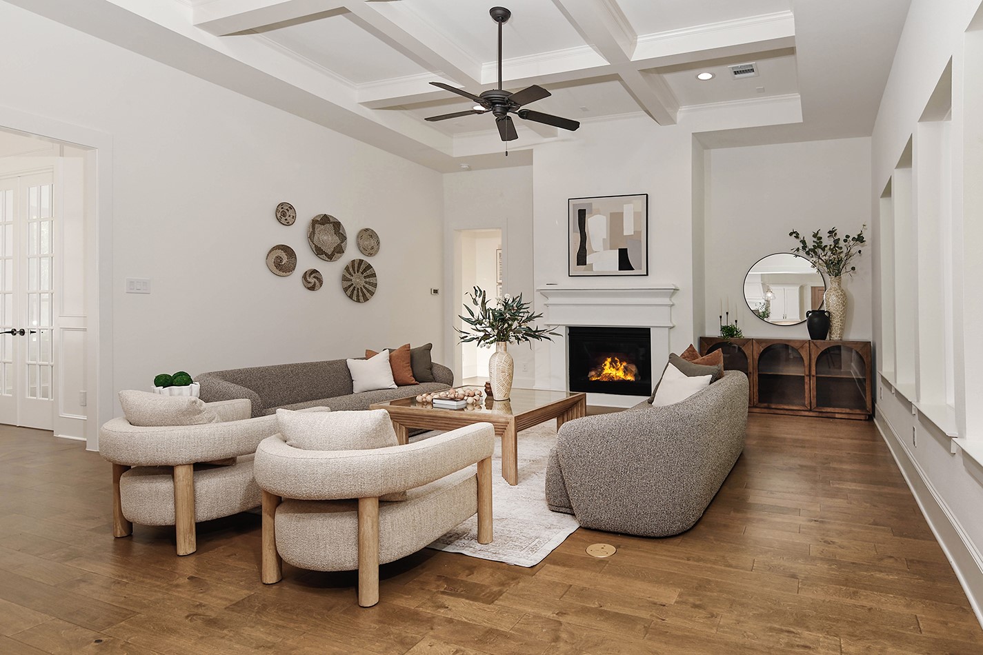 11709 Grand N Road Willis, TX 77378 - Photo 7 of 37 Living room features a modern fireplace, high coffered ceiling, pleasing neutral color palette, and ample space to float your furniture (with convenient floor outlets).