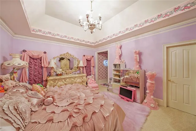 a spacious bedroom with a large bed and a chandelier