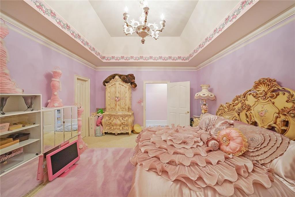 1827 Poplar Springs Road Hiram, GA 30141 - Photo 20 of 45 a spacious bedroom with a large bed and a chandelier