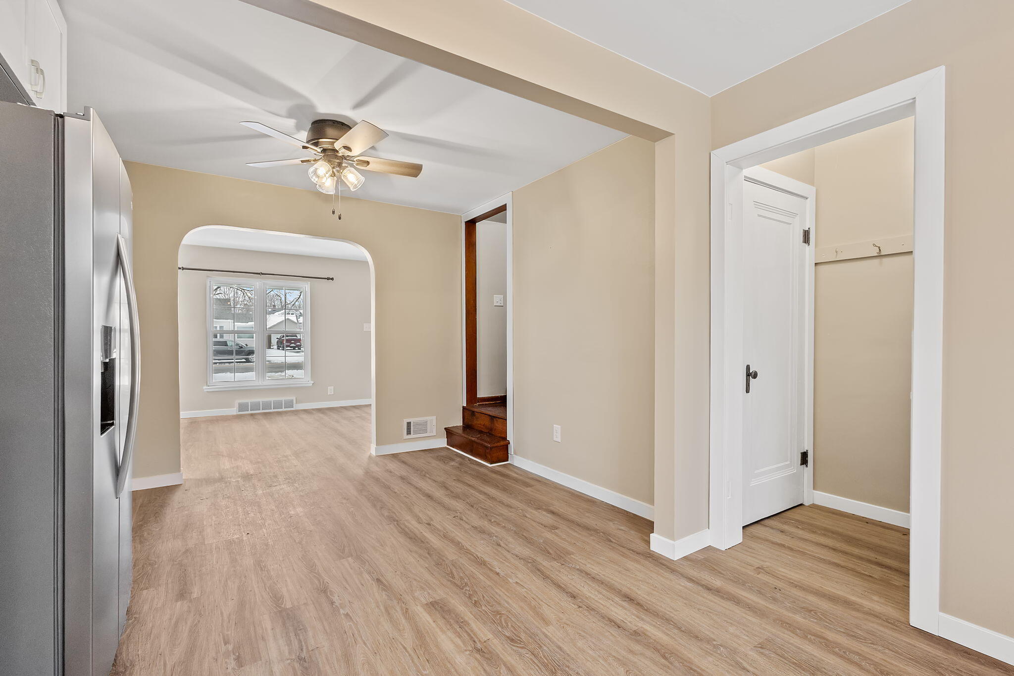 314 Cline Avenue Griffith, IN 46319 - Photo 11 of 36 an empty room with wooden floor chandelier fan and windows