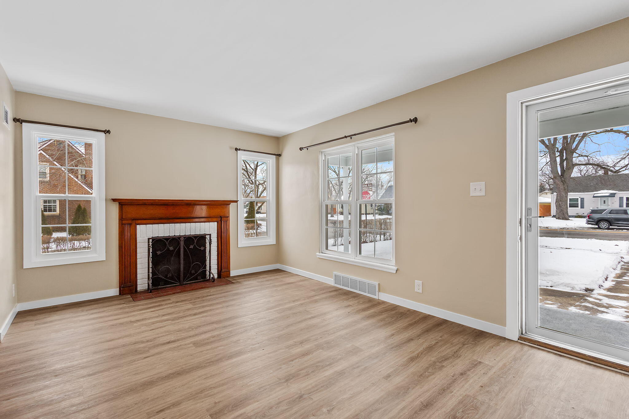 314 Cline Avenue Griffith, IN 46319 - Photo 3 of 36 an empty room with windows fireplace and wooden floor