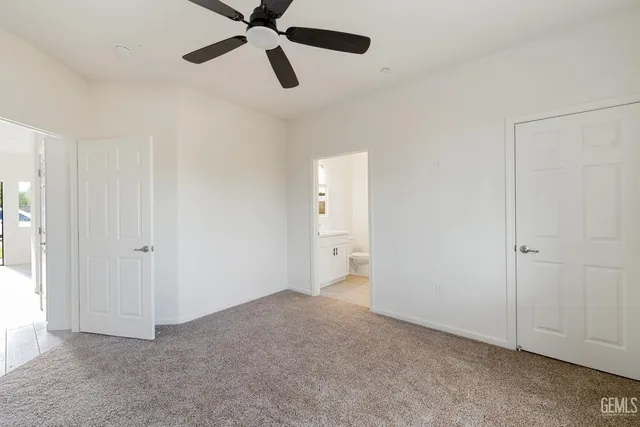 a view of an empty room and chandelier fan