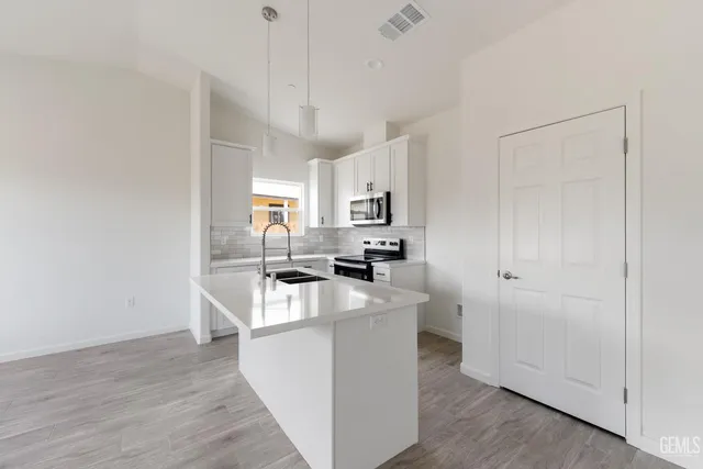 a kitchen with cabinets and wooden floor
