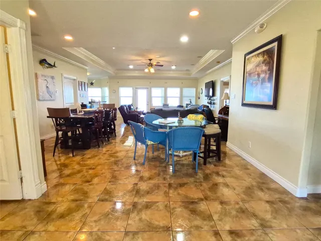 a living room with furniture a large window and dining table