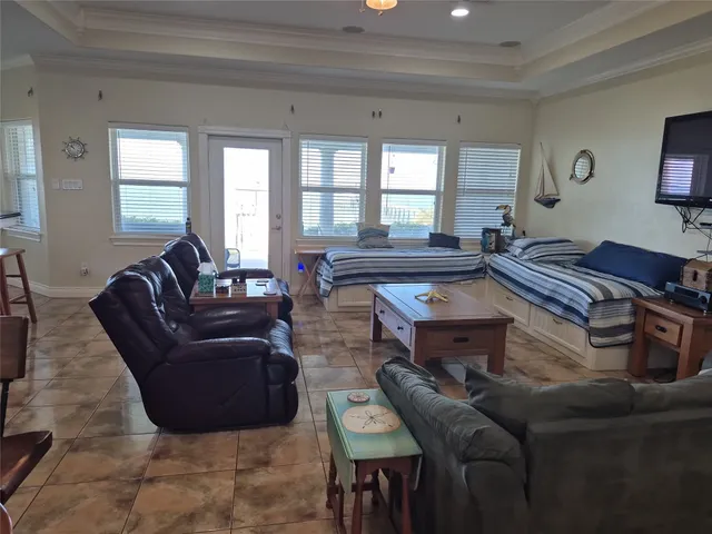 a view of a kitchen with kitchen island a counter top space a sink a window and stainless steel appliances