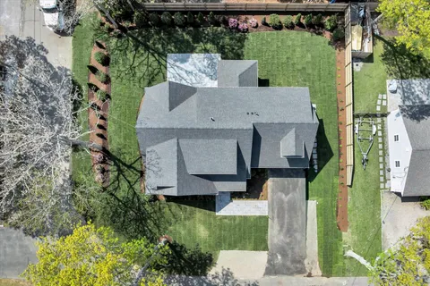 an aerial view of a house with a yard large tree and a fountain