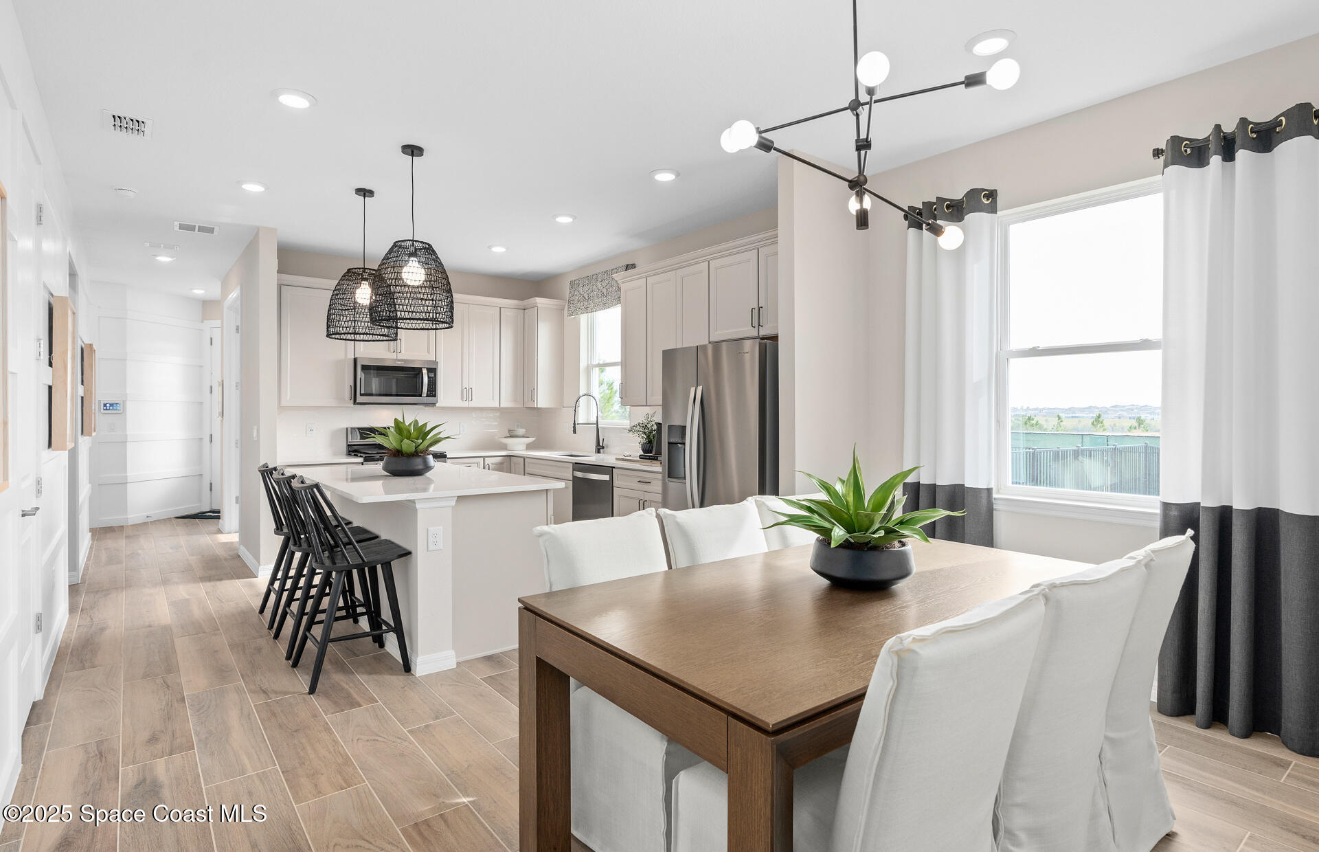3494 Bubbles Court Melbourne, FL 32901 - Photo 12 of 22 a kitchen with stainless steel appliances a dining table chairs and refrigerator