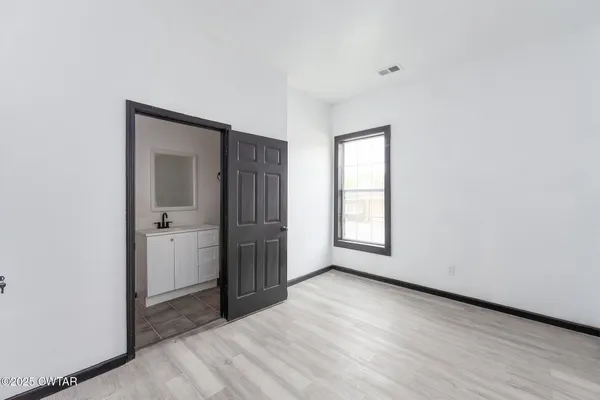an empty room with windows and closet