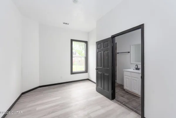 an empty room with windows and closet