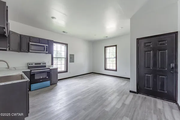 wooden floor in kitchen and a kitchen with a stove top oven