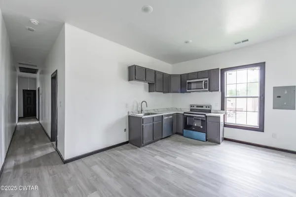 a kitchen with stainless steel appliances granite countertop a stove a sink and a refrigerator