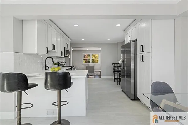 a kitchen with white cabinets and stainless steel appliances