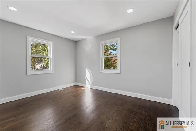 an empty room with wooden floor and a bathroom