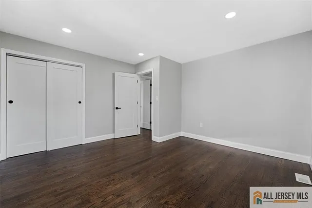 a bed sitting in a spacious bedroom next to a window