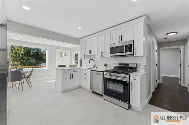 a kitchen with white cabinets and appliances