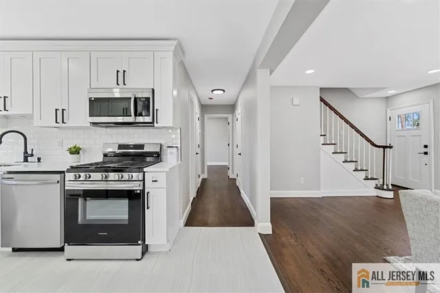 a kitchen with stainless steel appliances granite countertop a stove a sink and a microwave