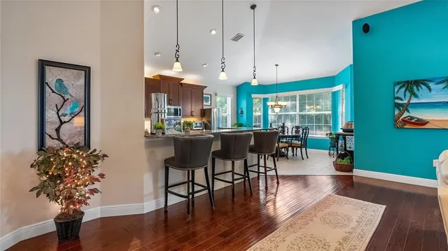 a dining room with furniture potted plants and wooden floor