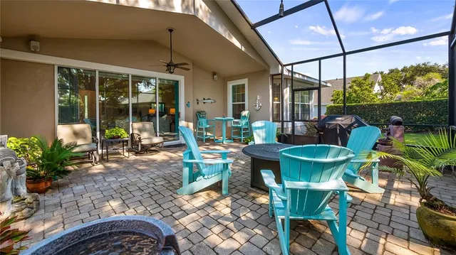 a view of a patio with table and chairs potted plants with floor to ceiling window and potted plants