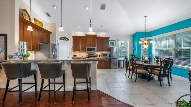 a dining room with furniture a chandelier and kitchen view