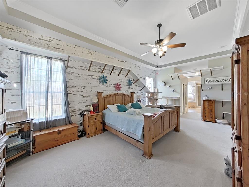 10639 Brave Lane Hudson, FL 34667 - Photo 11 of 54 a bedroom with furniture and a chandelier