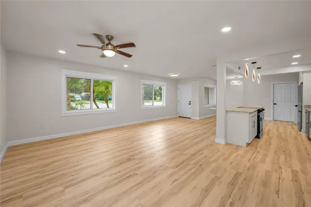 a view of an empty room with a window and wooden floor