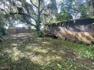 a backyard of a house with lots of green space and lake view