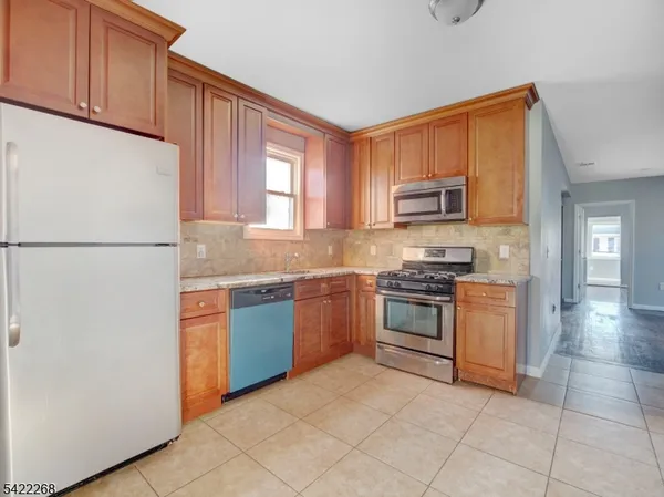 a kitchen with granite countertop a refrigerator stove top oven and sink