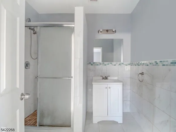 a bathroom with a shower a mirror and a sink