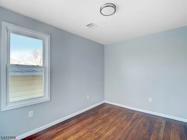 a view of a small space with wooden floor and a window