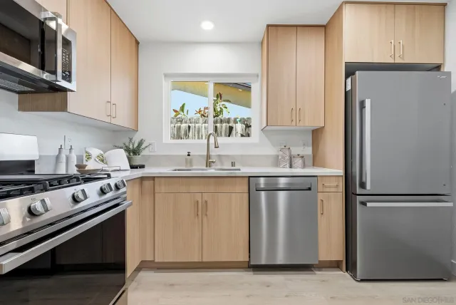 a kitchen with stainless steel appliances granite countertop a refrigerator stove and sink