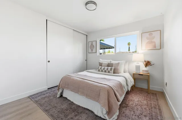 a bedroom with a bed and a painting on the wall