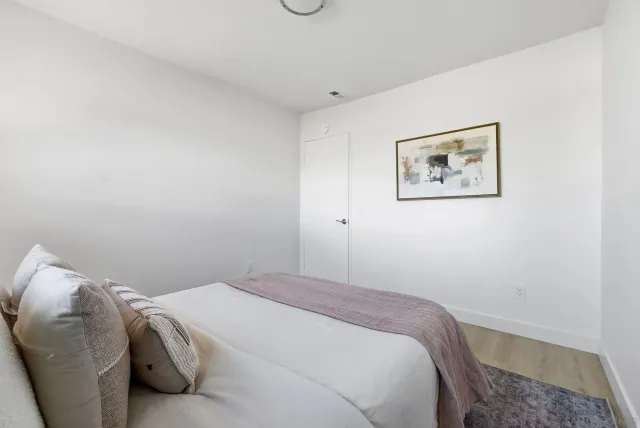 a bedroom with a bed and a wall painting