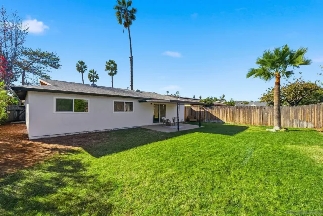 a view of a house with backyard and sitting area