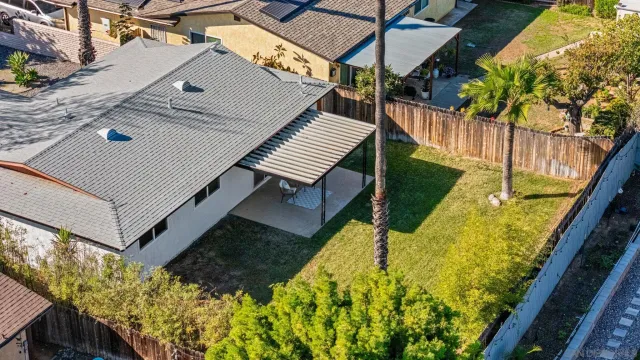 an aerial view of a house with a yard and large tree