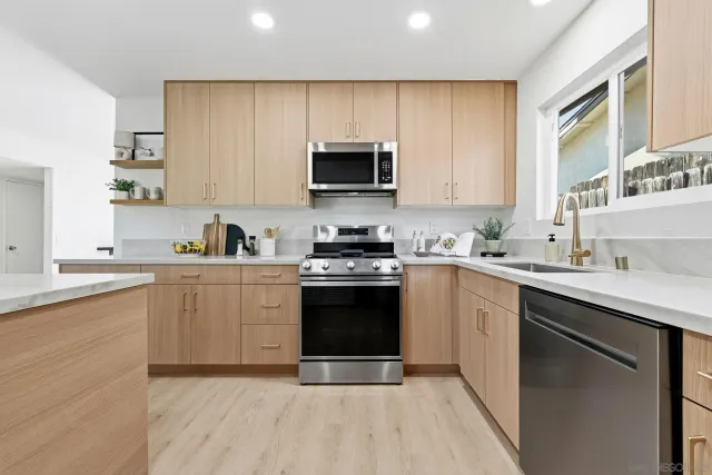 a kitchen with a sink a stove a microwave and cabinets