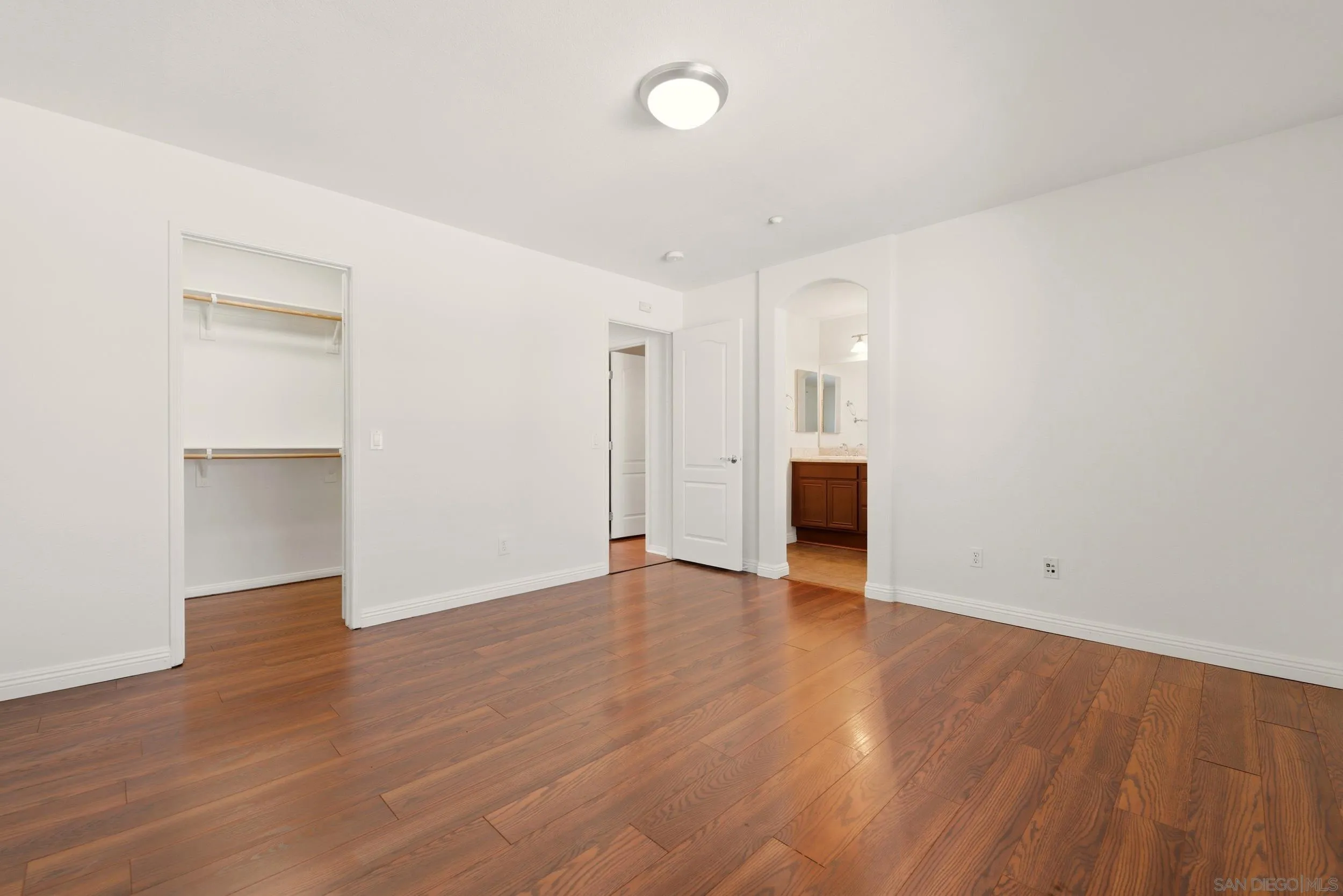 16953 New Rochelle Way, Unit 62 San Diego, CA 92127 - Photo 9 of 21 an empty room with wooden floor and windows