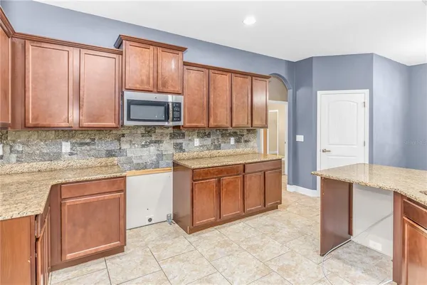 a kitchen with stainless steel appliances granite countertop a stove a sink and a microwave
