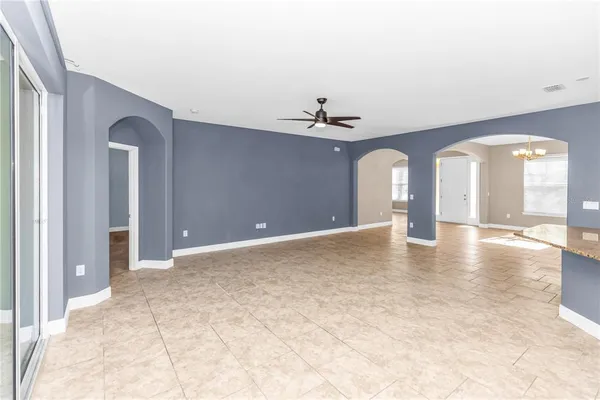 a view of a room with chandelier fan and glass door
