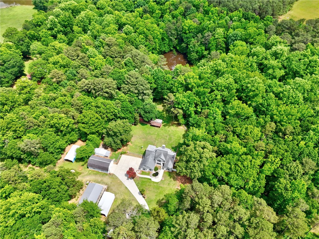 1016 Campbell Road Belton, SC 29627 - Photo 38 of 50 An aerial perspective reveals a private residence nestled amidst verdant forestry with a peaceful pond nearby.
