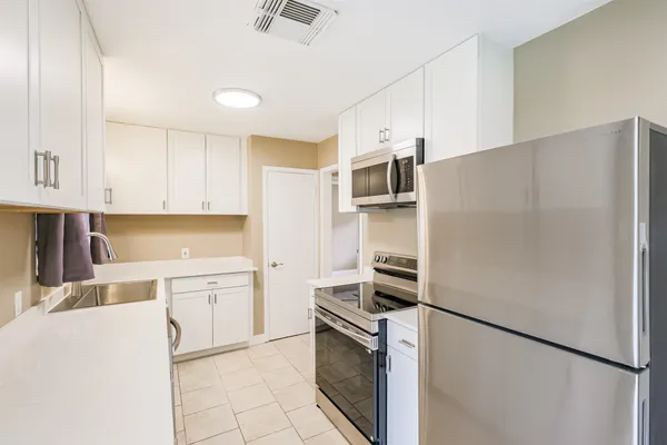 a kitchen with stainless steel appliances a refrigerator sink and cabinets
