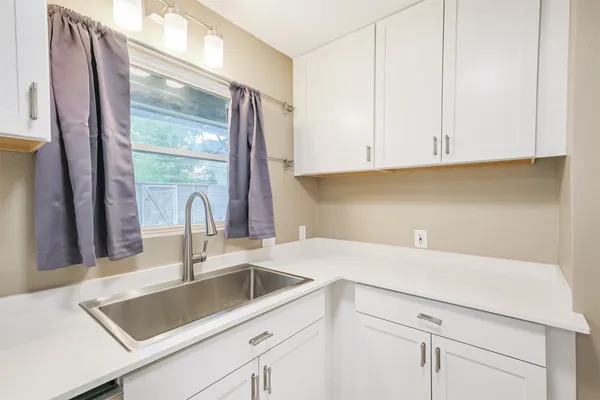 a kitchen with a sink cabinets and a window