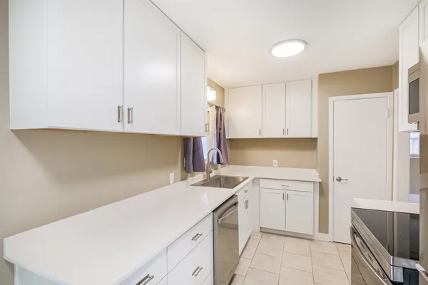 a view of a kitchen with white cabinets