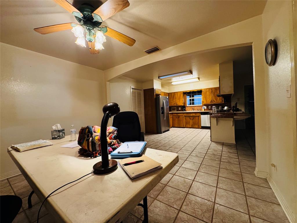 1111 East Sammy Baugh Avenue Rotan, TX 79546 - Photo 13 of 23 a kitchen with stainless steel appliances kitchen island granite countertop a table chairs and a refrigerator