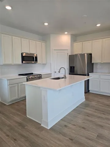 a kitchen with kitchen island a refrigerator sink and microwave